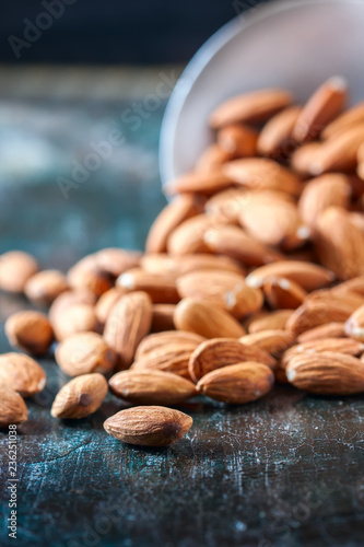 Almond on wooden background. Peeled almonds. © Gulsina