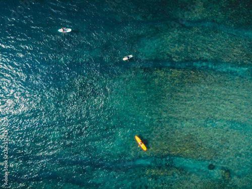 Aerial view of surfer and blue ocean water. Surfing in ocean
