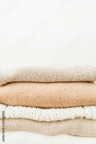 Warm woolen sweaters and pullovers stack on white background. Woman fashion clothes on white background.