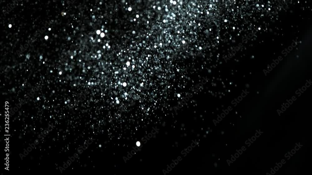 Super slow motion of glittering silver particles on black background. Shallow depth of focus. Filmed on high speed cinema camera, 1000 fps. Super slow motion of glittering silver particles on black background. Shallow depth of focus. Filmed on high speed cinema camera, 1000 fps.