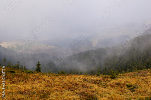 Amazing landscape from Ciucas Peak in the Carpathian Mountains, Romania, on a hazy autumn day, when fog is lifting.