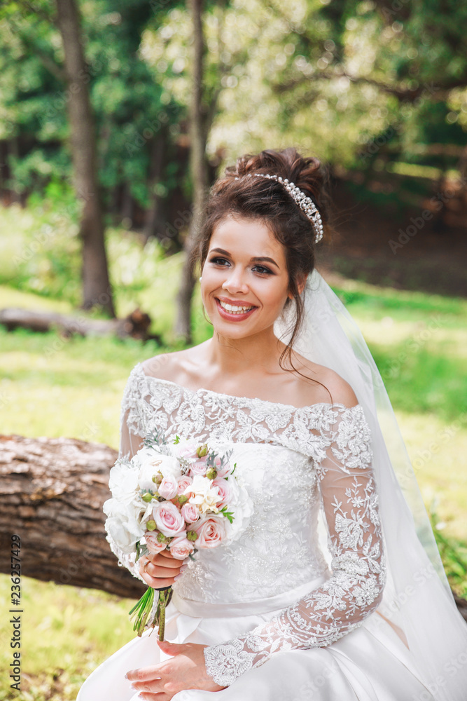 Beautiful happy bride with bouquet of flowers in park Beautiful happy bride with bouquet of flowers in park
