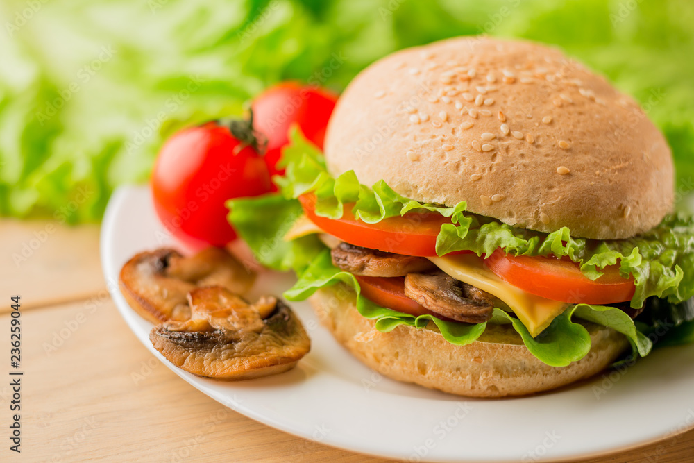 Vegetarian burger with fresh salad on the plate, close up Vegetarian burger with fresh salad on the plate, close up