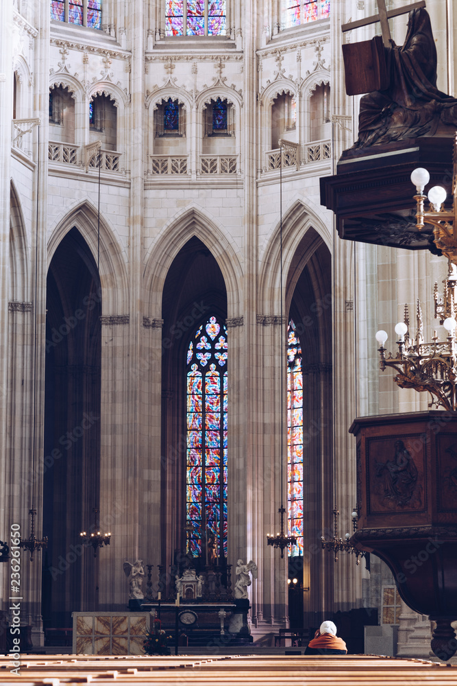 people praying - interior view of Saint Pierre Cathedral in Nantes - Nantes, FRANCE - NOVEMBER 2018.