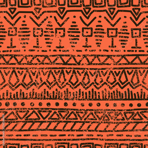 Seamless ethnic grunge background. Geometric pattern. Handmade. Tribal motifs. Black elements on an orange background in grunge style. Vintage vector illustration.