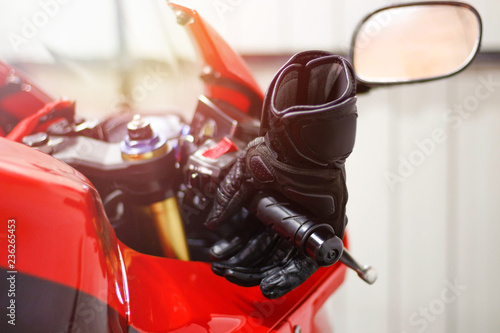 Black leather motorcycle gloves is lying on a red sports bike.