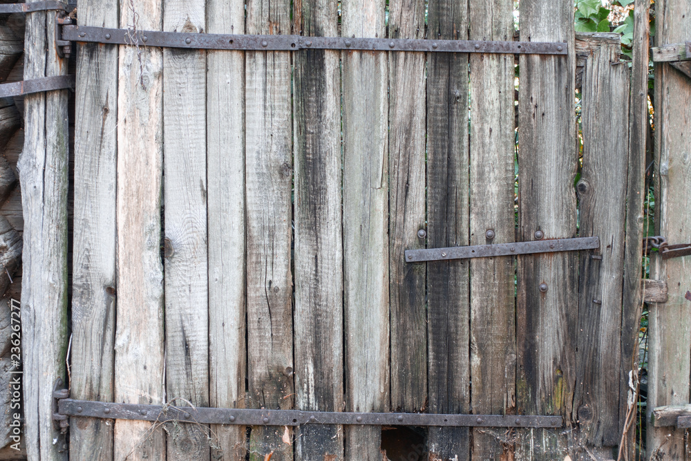 Old wooden fence with rusty metal plates. background.