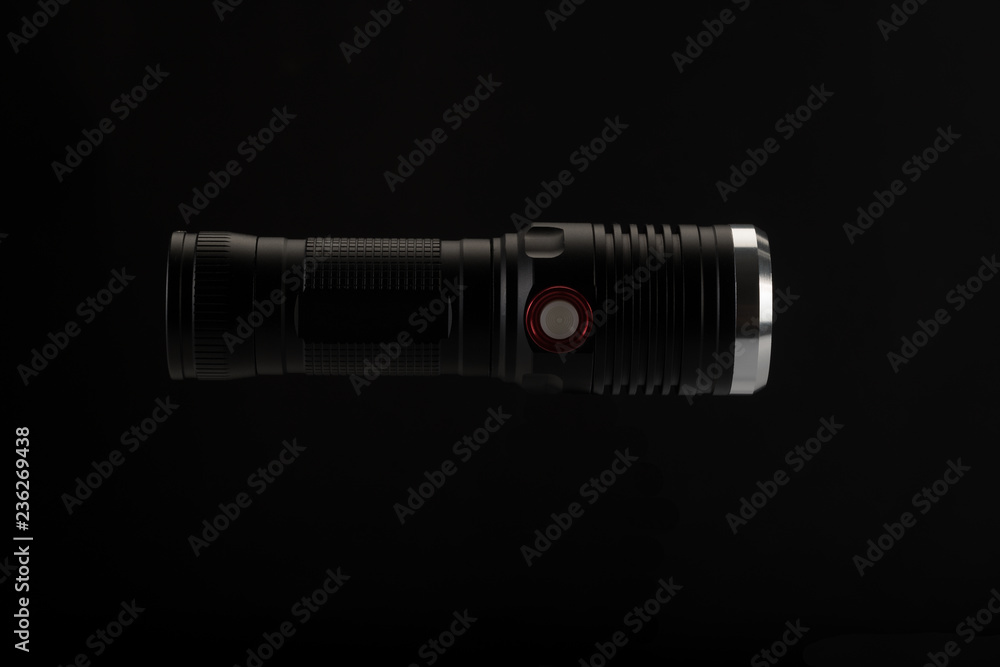 Tactical flashlight on a black background Tactical flashlight on a black background