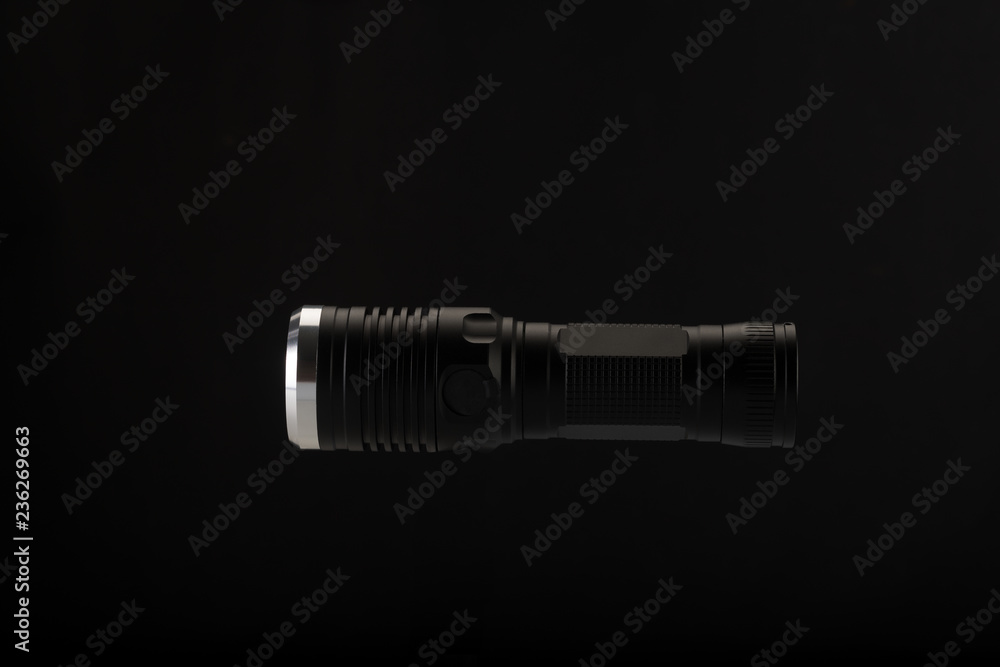 Tactical flashlight on a black background Tactical flashlight on a black background