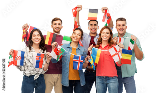 international friendship and people concept - group of smiling friends with flags of different countries string over white background
