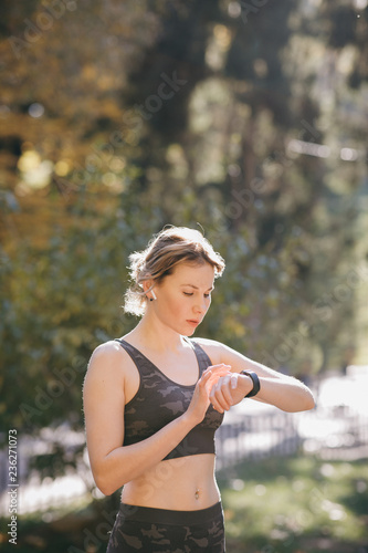 Woman using her smartwatch touchscreen wearable technology device in morning lights © uflypro