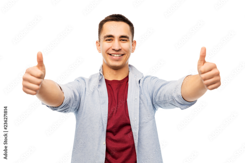 gesture and people concept - happy young man showing thumbs up over white background gesture and people concept - happy young man showing thumbs up over white background