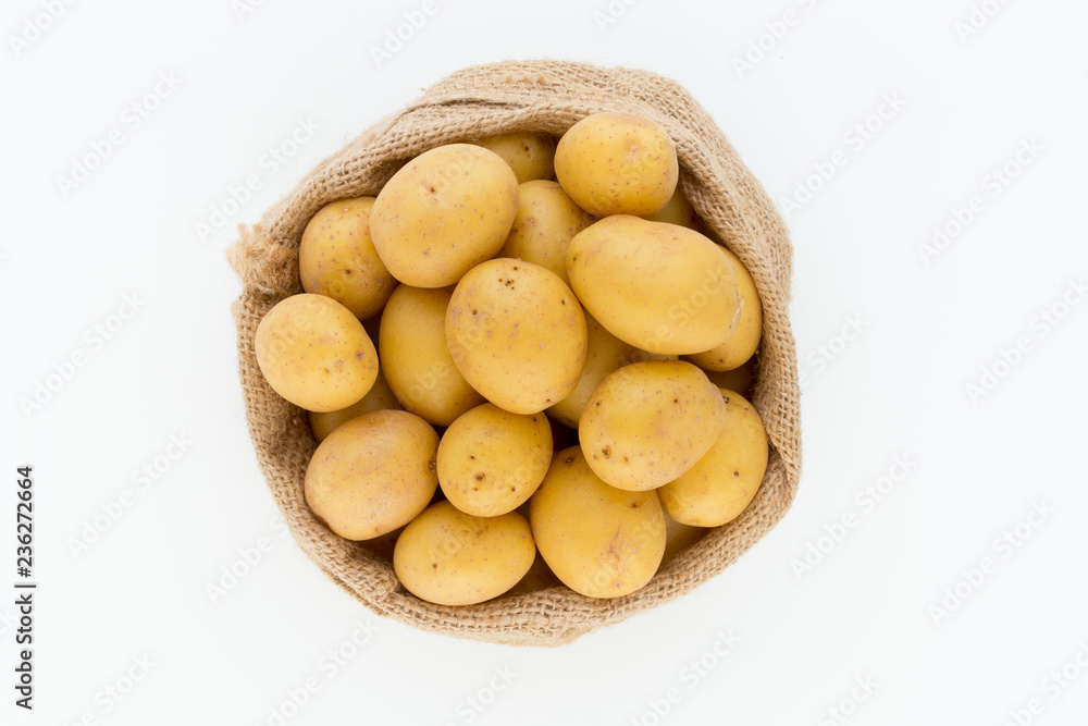Sack of fresh raw potatoes on wooden background, top view Sack of fresh raw potatoes on wooden background, top view