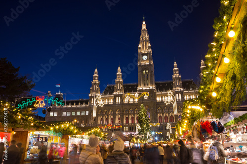 Famous Vienna Christkindlmarkt christmas fair in front of the town hall at Rathausplatz with tourists and people in festive mood on Advent evening.