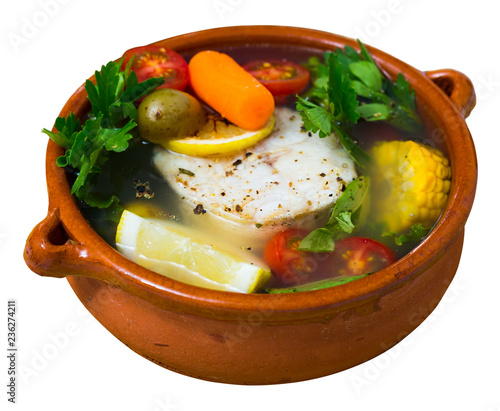 Fisherman soup cooked with boiled pollock, carrots, corn and greens photo