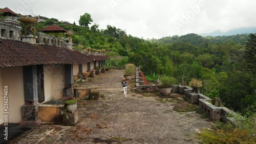 Aerial drone video of woman in abandoned hotel in Bedugul, Bali island.