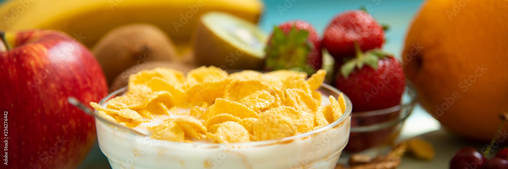 Tasty cornflakes with milk and fruits in glass bowl Tasty cornflakes with milk and fruits in glass bowl