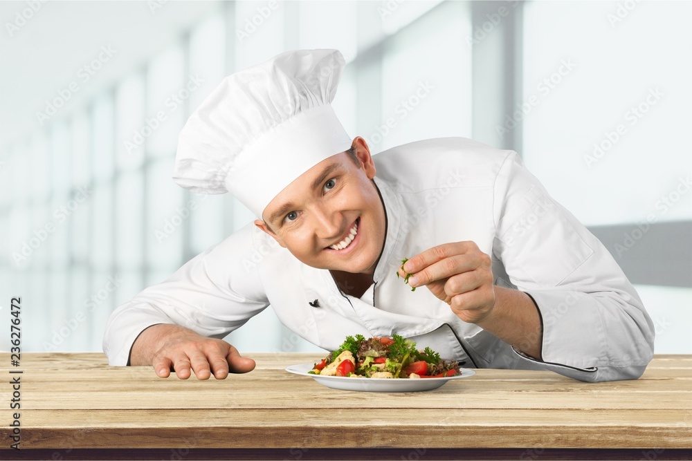 Portrait of a male chef cook preparing salad  isolated on