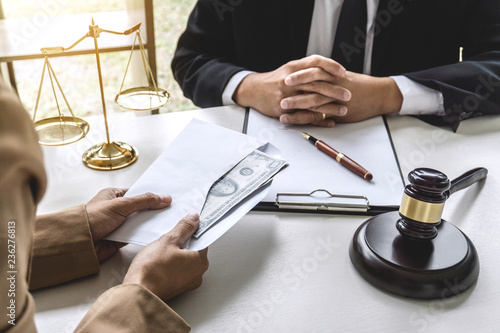 Business woman giving bribe money the form of dollar bills to mature counselor while give success the deal to finishing contract agreement, Bribery and corruption concept