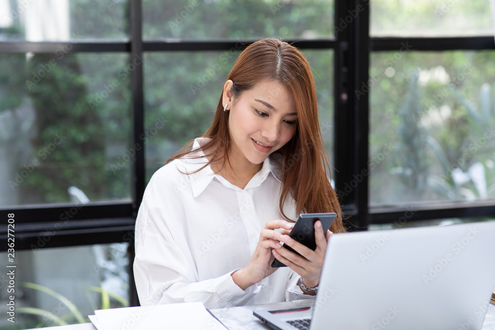 Beautiful Attractive Asian business woman holding smartphone for using social media in coffee shop cafe smile and happiness Beautiful Attractive Asian business woman holding smartphone for using social media in coffee shop cafe smile and happiness