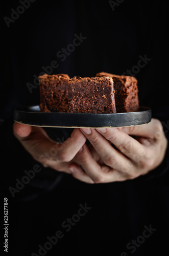 Hands of  woman holding a plate with  brownie
