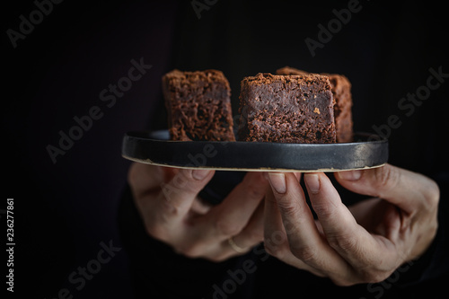 Hands of  woman holding a plate with  brownie photo