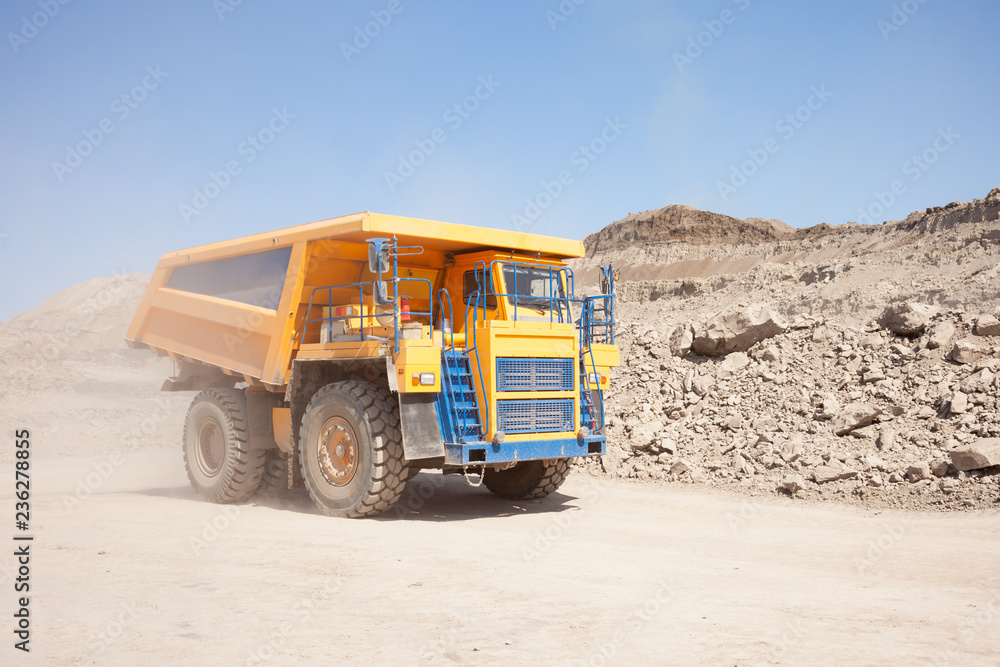 Yellow dump truck moving in a mine