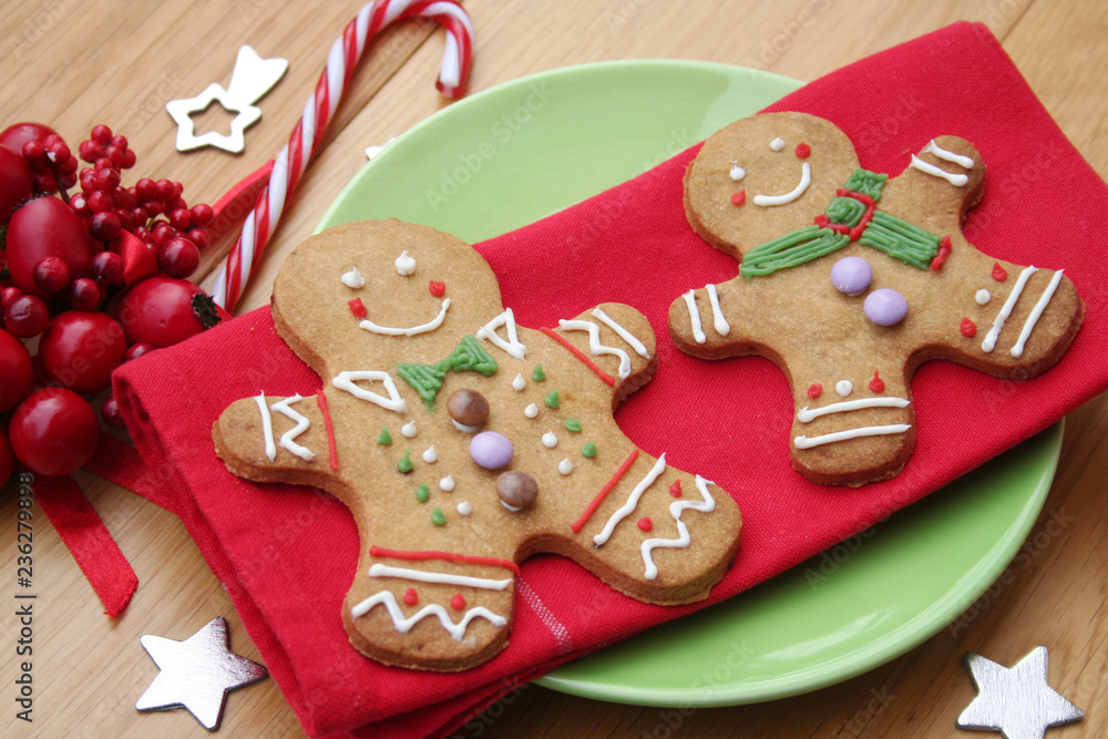 Gingerbread men cookies on red napkin on wooden table with Christmas decoration. Christmas festive background
