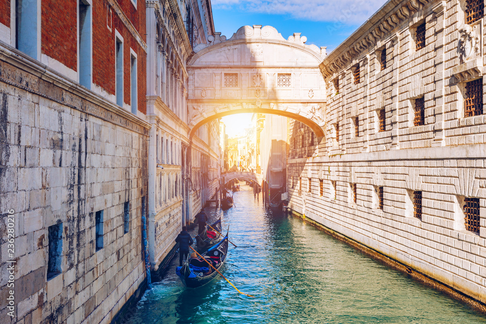 Fototapeta premium Widok na Most Westchnień i Kanał Rio de Palazzo lub de Canonica z Riva degli Schiavoni w Wenecji, Włochy. Most Canonica jest widoczny w tle.
