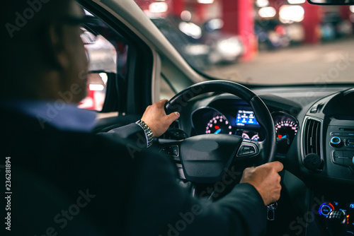 Fotografia Man driving car at night, hands on wheel