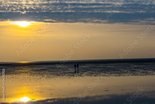 Spaziergänger im Wattenmeer Nordsee bei Sonnenuntergang