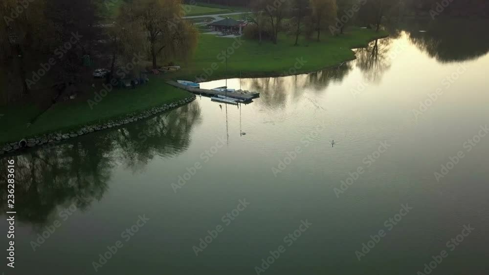 Aerial: Autumn evening flight over small pond in clear calm weather. Beautiful colorful nature reflecting in the water. Aerial: Autumn evening flight over small pond in clear calm weather. Beautiful colorful nature reflecting in the water.