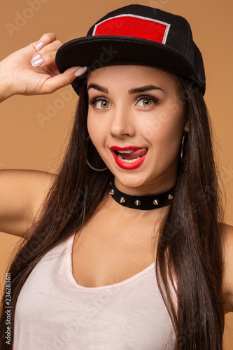 Hip-hop girl in cap with long dark hair. Fashion portrait of modern young woman in cap © nazarovsergey