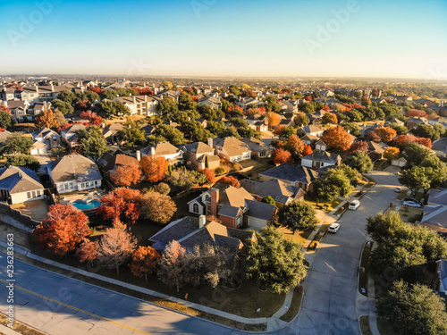 Top view planned unit development suburbs of Dallas, Texas, USA in autumn season. Picture from drone residential area with colorful fall foliage leaves under blue sky