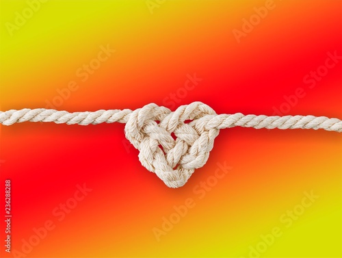 White rope in heart shape knot on background. Love concept.