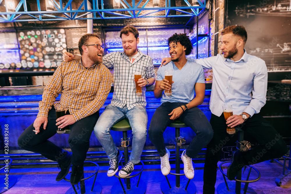 Fototapeta premium Friends sitting at bar and drinking beer.