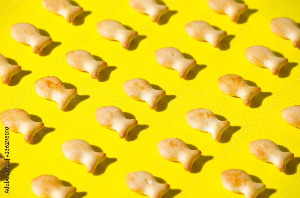 Cookies in form fish, yellow background, in bright sun with hard shadows. Cookies in form fish, yellow background, in bright sun with hard shadows.