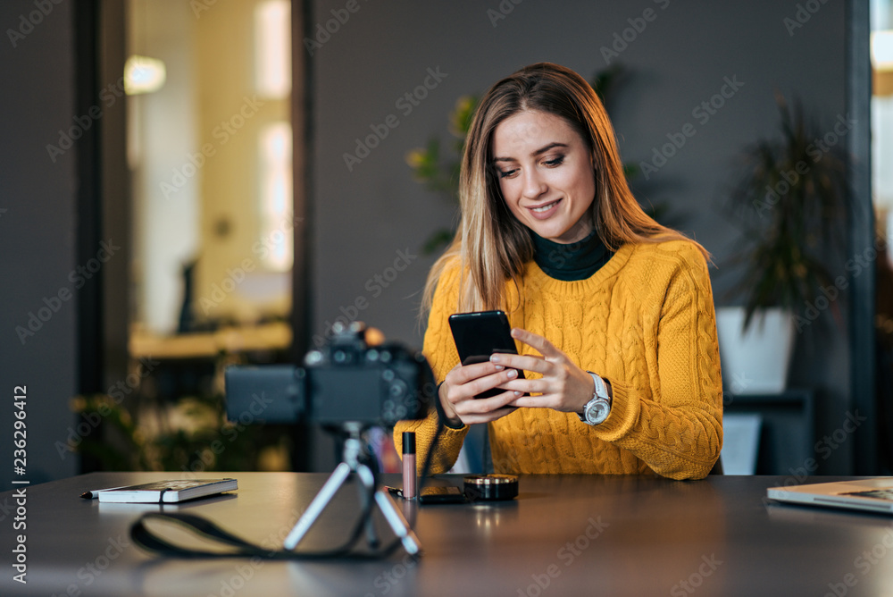 Young female vlogger on a break, using mobile phone. Young female vlogger on a break, using mobile phone.