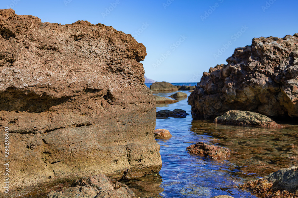 big boulders lying in water on seashore
