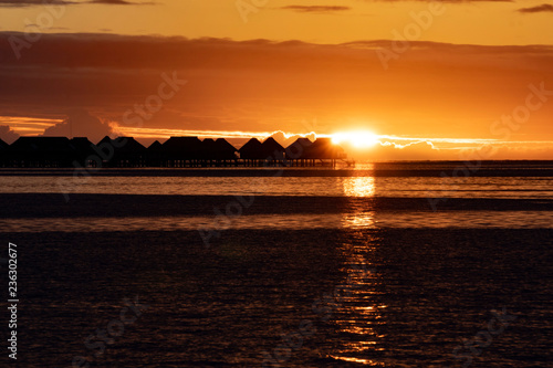 Overwater bungalow sunset in moorea french polynesia photo