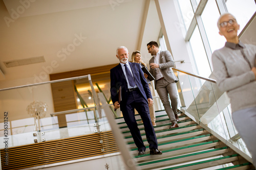 Businessmen and businesswomen walking and taking stairs in an office building