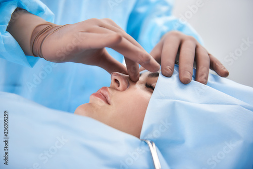 Close up photo of doctor hands palpating nose before operation
