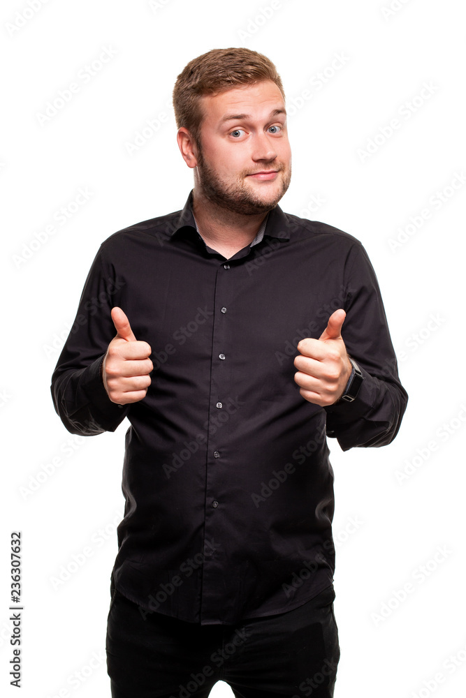 Image of young attractive man dressed in black shirt standing over white background looking at camera and showing thumbs up gesture. Image of young attractive man dressed in black shirt standing over white background looking at camera and showing thumbs up gesture.