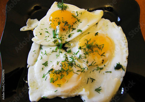 Roasted eggs on the black plate and dill over