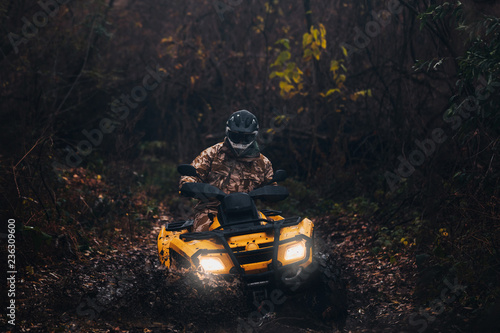 shot of quad bike rider driving in full protective equipment
