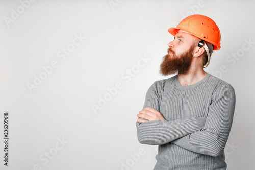 Foto Young brutal construction worker in hard hat on a white background