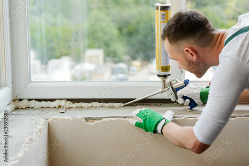 Worker is applying polyurethane foam photo