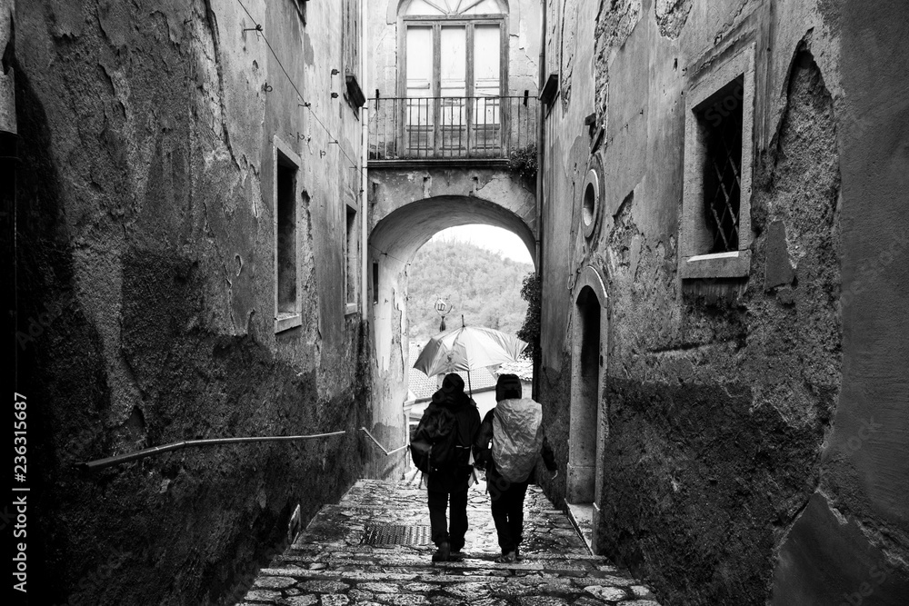 a couple walks in the alleys of Tufo, wine town Greco di Tufo, province of Avellino, Italy