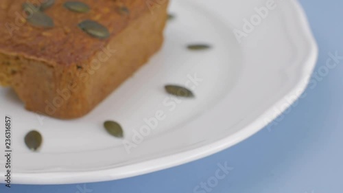 Gluten-Free pumpkin bread with pumpkin seed in white plate set on light blue background. photo