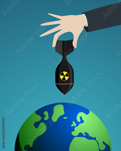 Nuclear threat: Hand holding an nuclear bomb over the planet earth